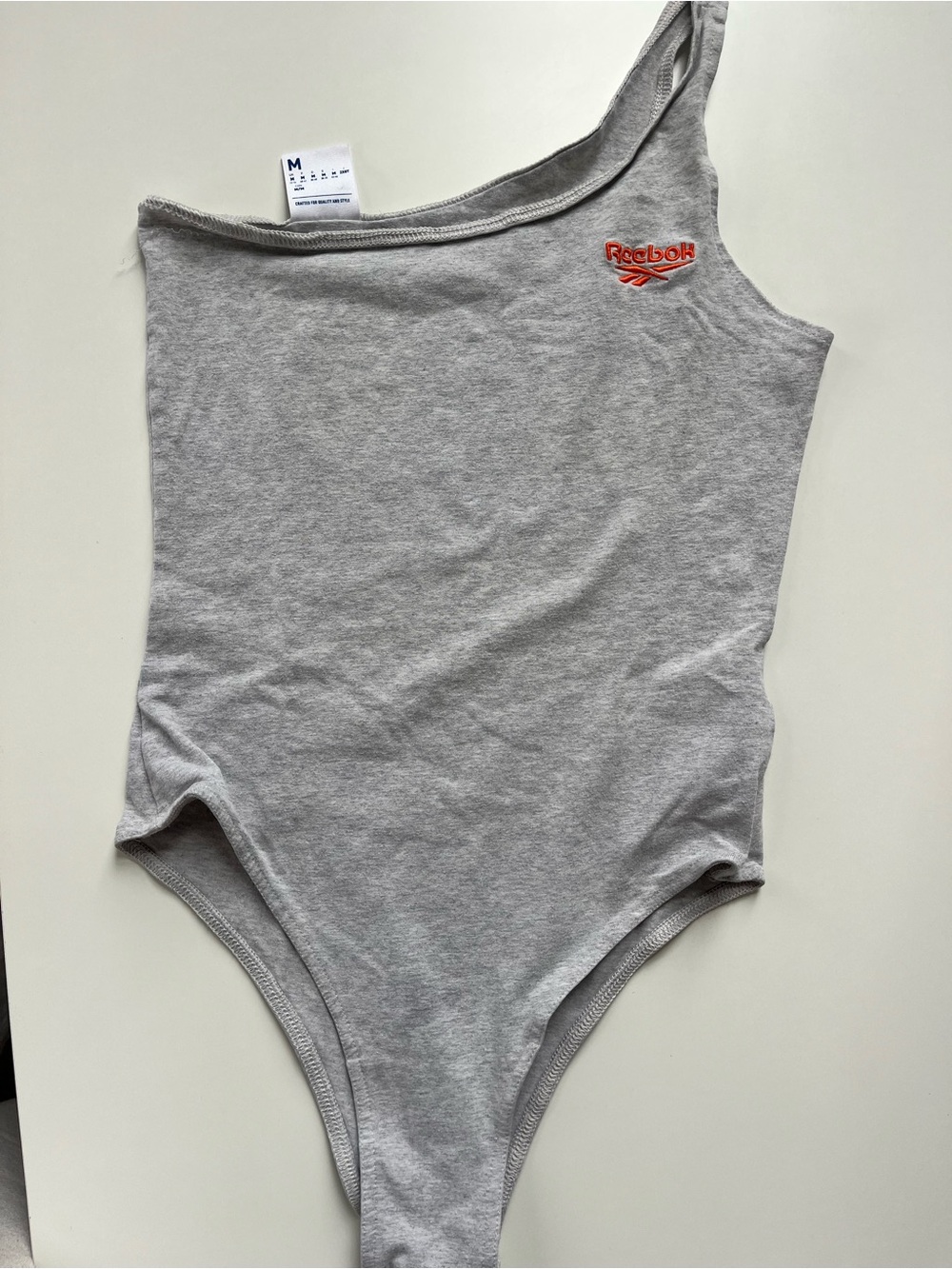 Reebok women Light Grey asymetric Bodysuit with Red Logo